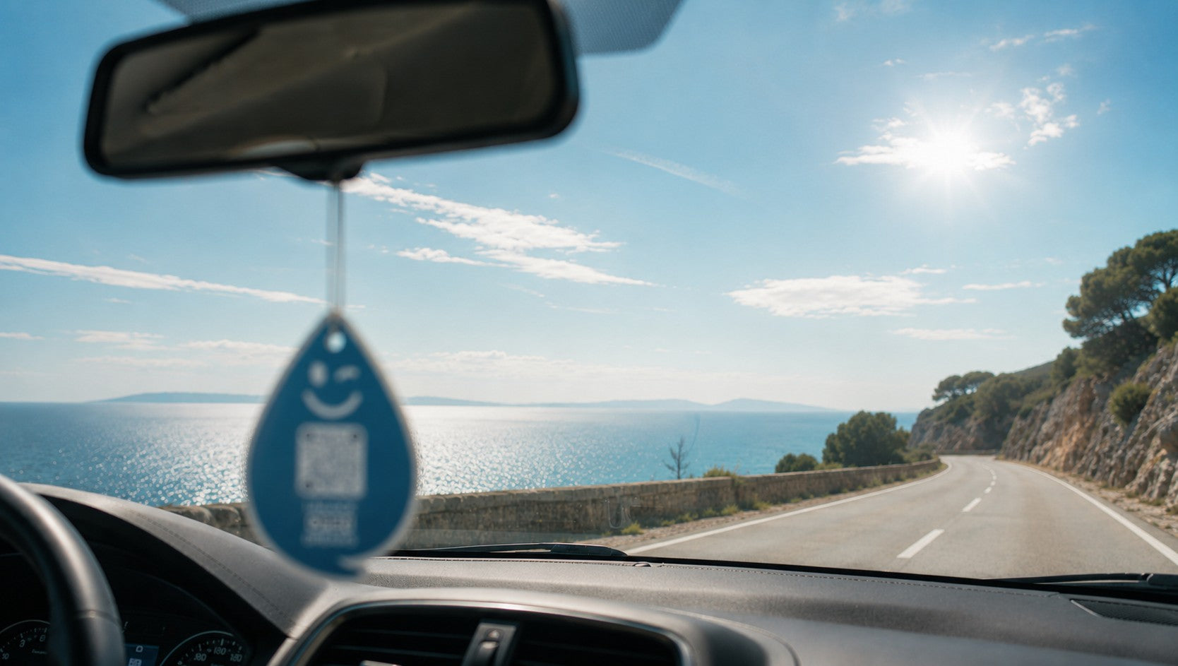 Paradise Aqua OPEN Auto-Duftanhänger von ScanTheDrop auf einer offenen Küstenfahrt am Meer